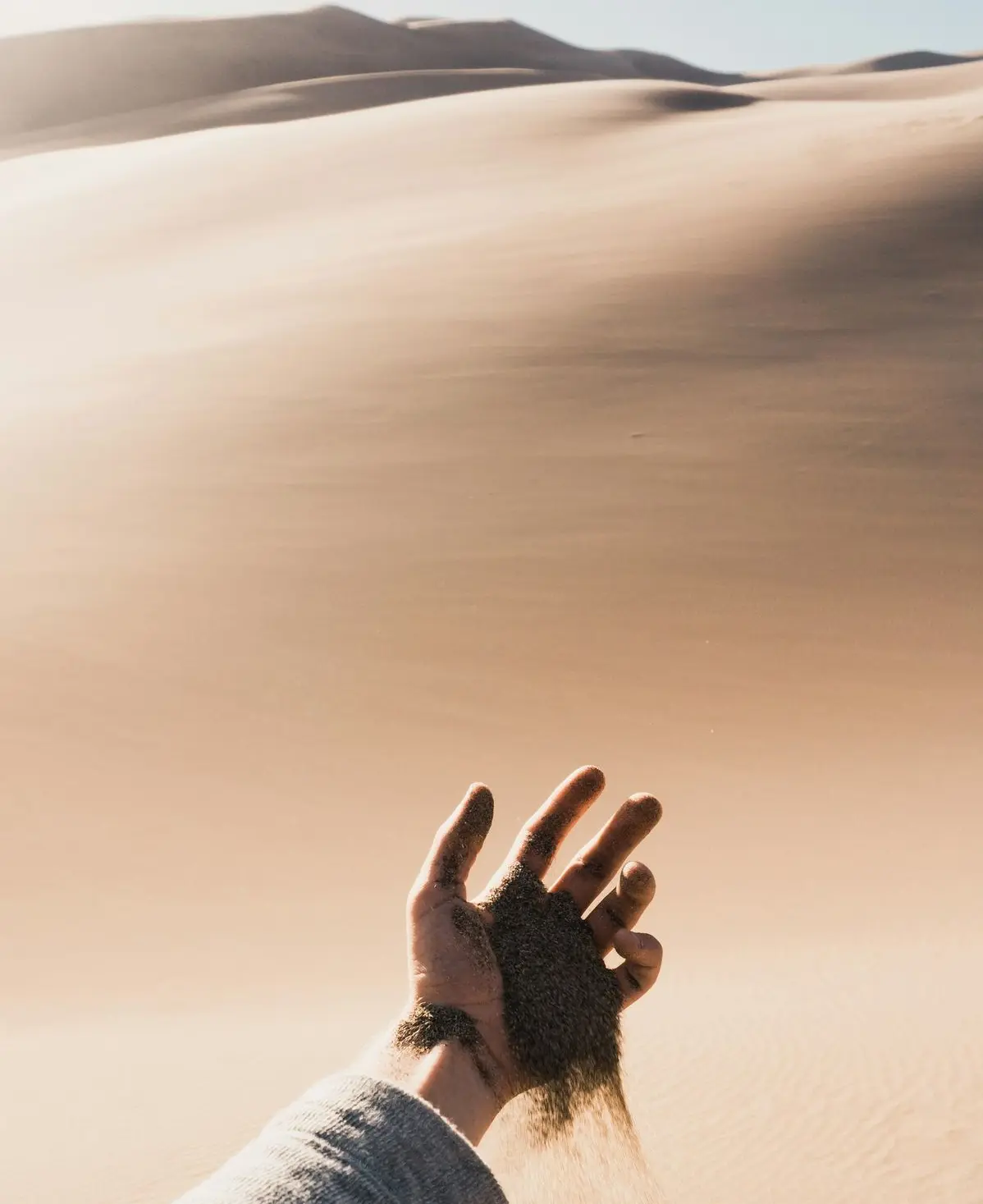 person dropping sand from his hand during daytinme